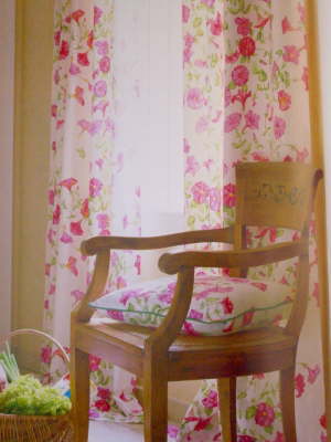 Blumengardine, mit rosa Blüten vor einem Stuhl